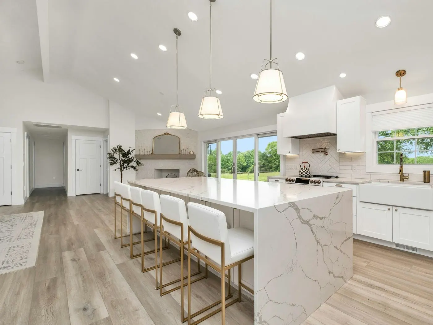 Clean white kitchen with a long marble island